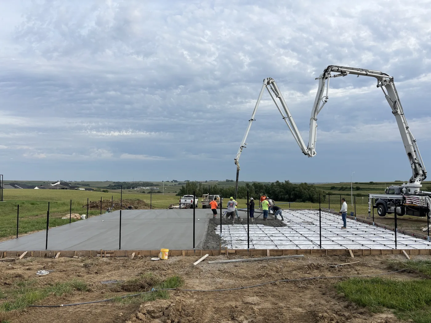 Concrete pump placing a pickleball court slab over a post-tension cable grid