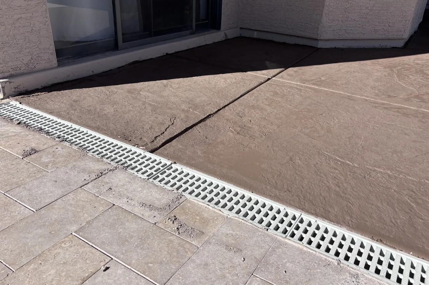 Textured concrete deck with a channel drain along a sliding door on a DC Construction job