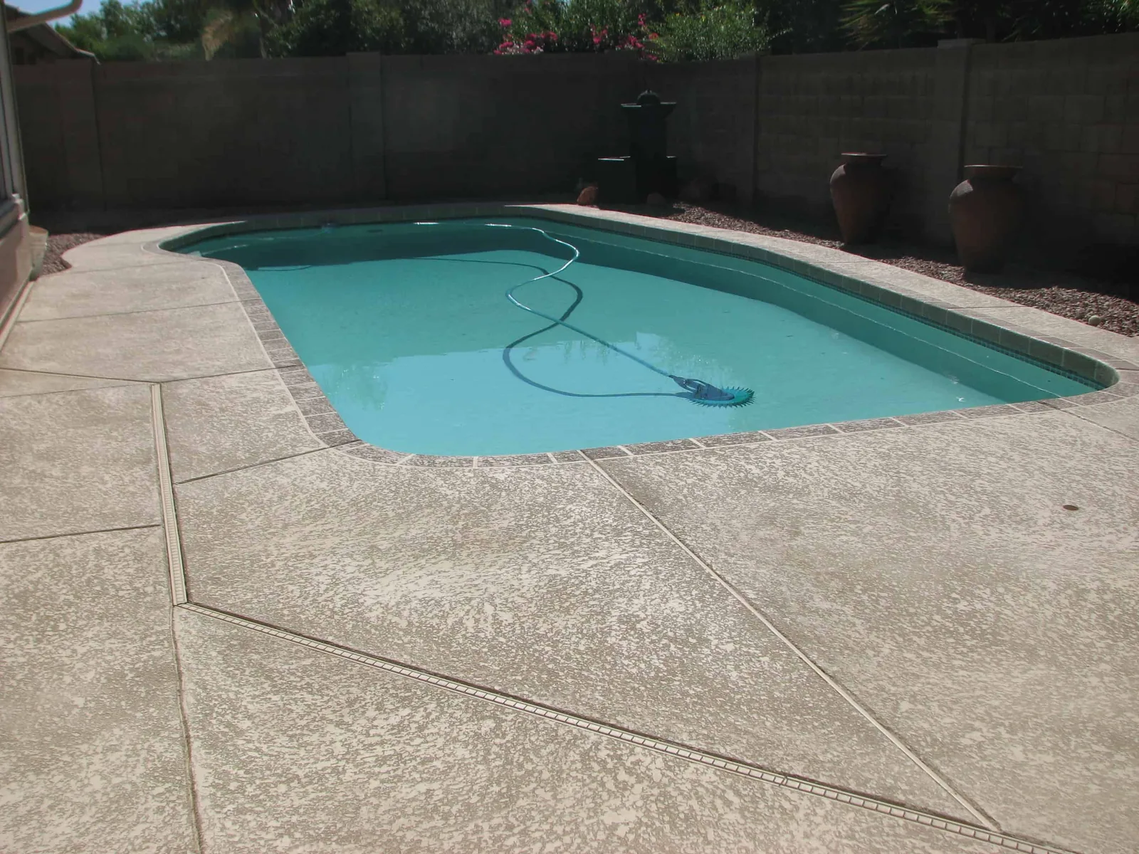 Resurfaced pool deck with a light textured cool-deck finish around a backyard pool in Arizona